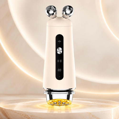 NACRE FORM 3-in-1 RF and EMS Facial Massager with yellow LED light therapy, displayed in a premium skincare product photograph. The beige rechargeable electric face massager features dual 3D diamond-cut metallic massage rollers, an ergonomic handheld body, a black control panel with silver power button and a chrome treatment head with eight metallic contact points. The yellow LED light is illuminated beneath the device, creating a warm golden glow on the cream marble surface. 