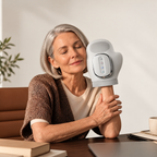 NACRE FORM™ electric hand massager with heat and air compression, worn by a mature woman relaxing at home, designed for soothing hand massage, tired fingers, everyday hand stiffness and comfortable self-care.